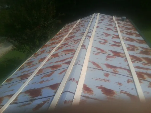 Rusted metal roof panels with new wood purlins before replacement — Storm Damage Roof Repair in Deweyville by Roofing Brothers