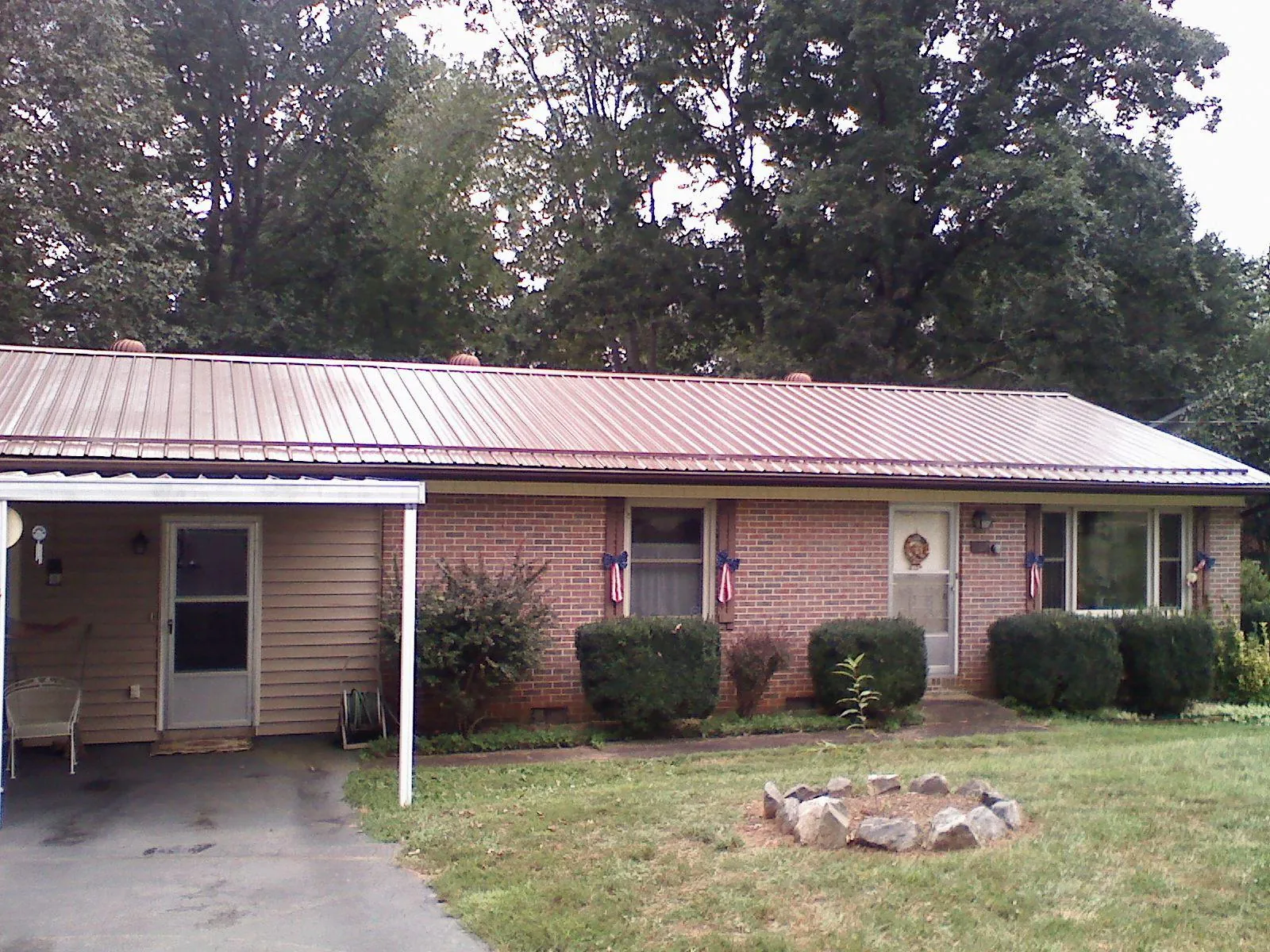Bronze metal roof and carport on a brick ranch home — Roof Repair work by our crew in Deweyville